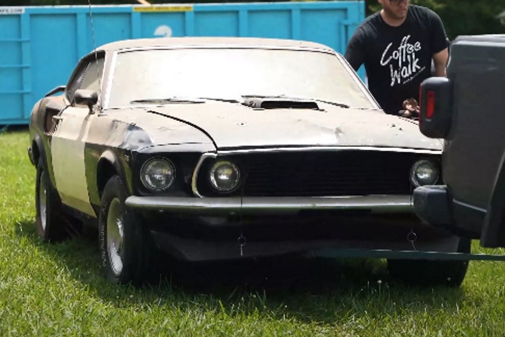 A 1969 R-Code Ford Mustang being towed, black, front quarter view