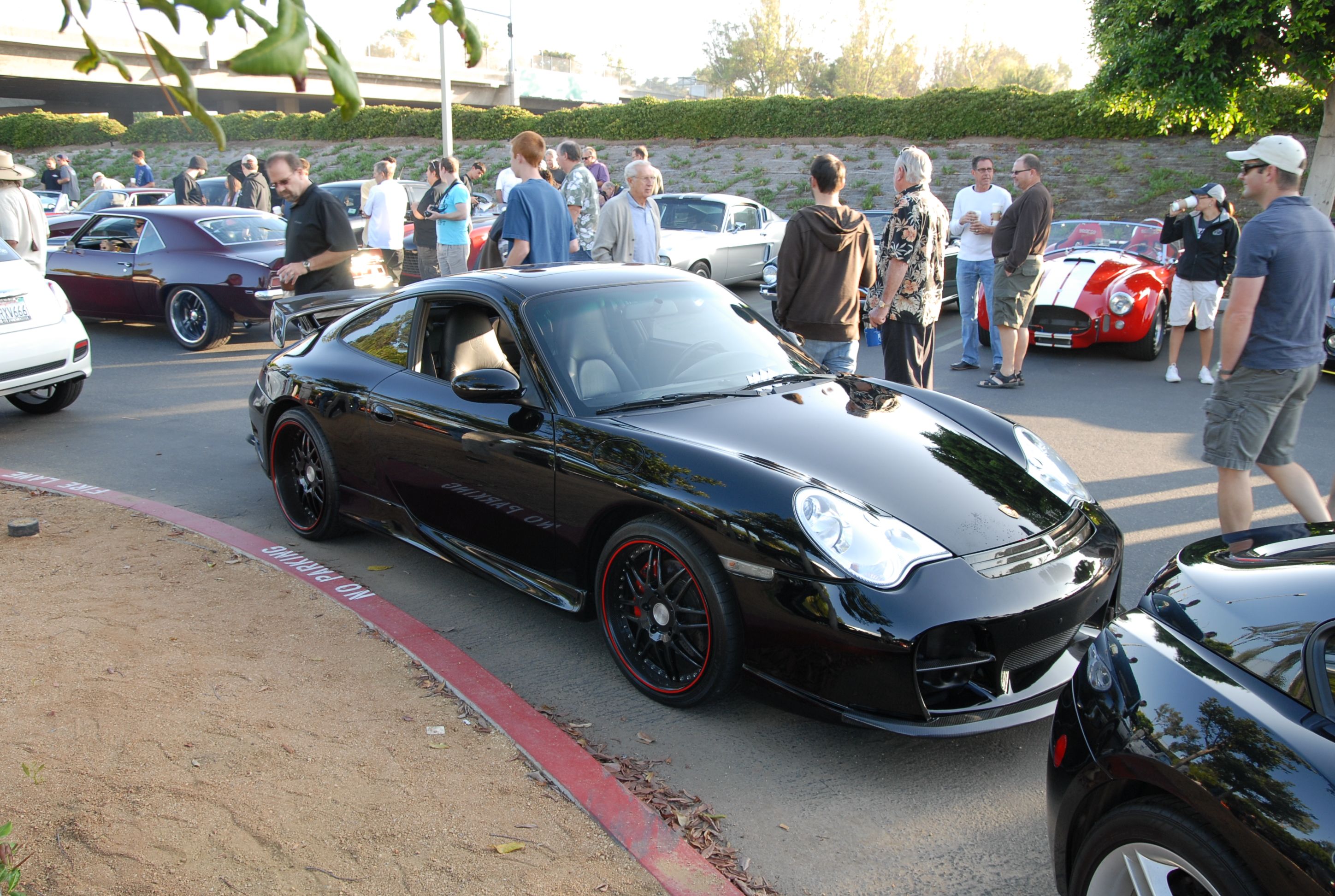 Car show crowd enjoying cars with a Porsche in the foreground