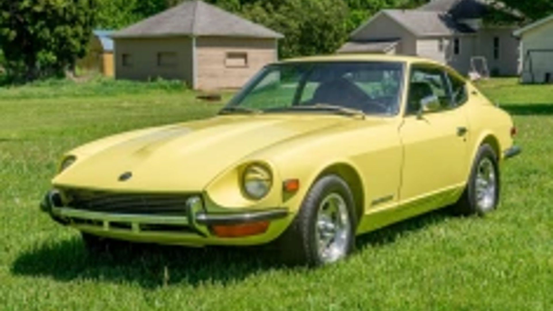 Driver's side shot of a yellow Nissan Fairlady Z. 